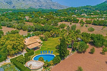 An aerial view of a house with a large pool