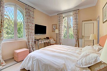 A bedroom with a large bed and a flat screen tv