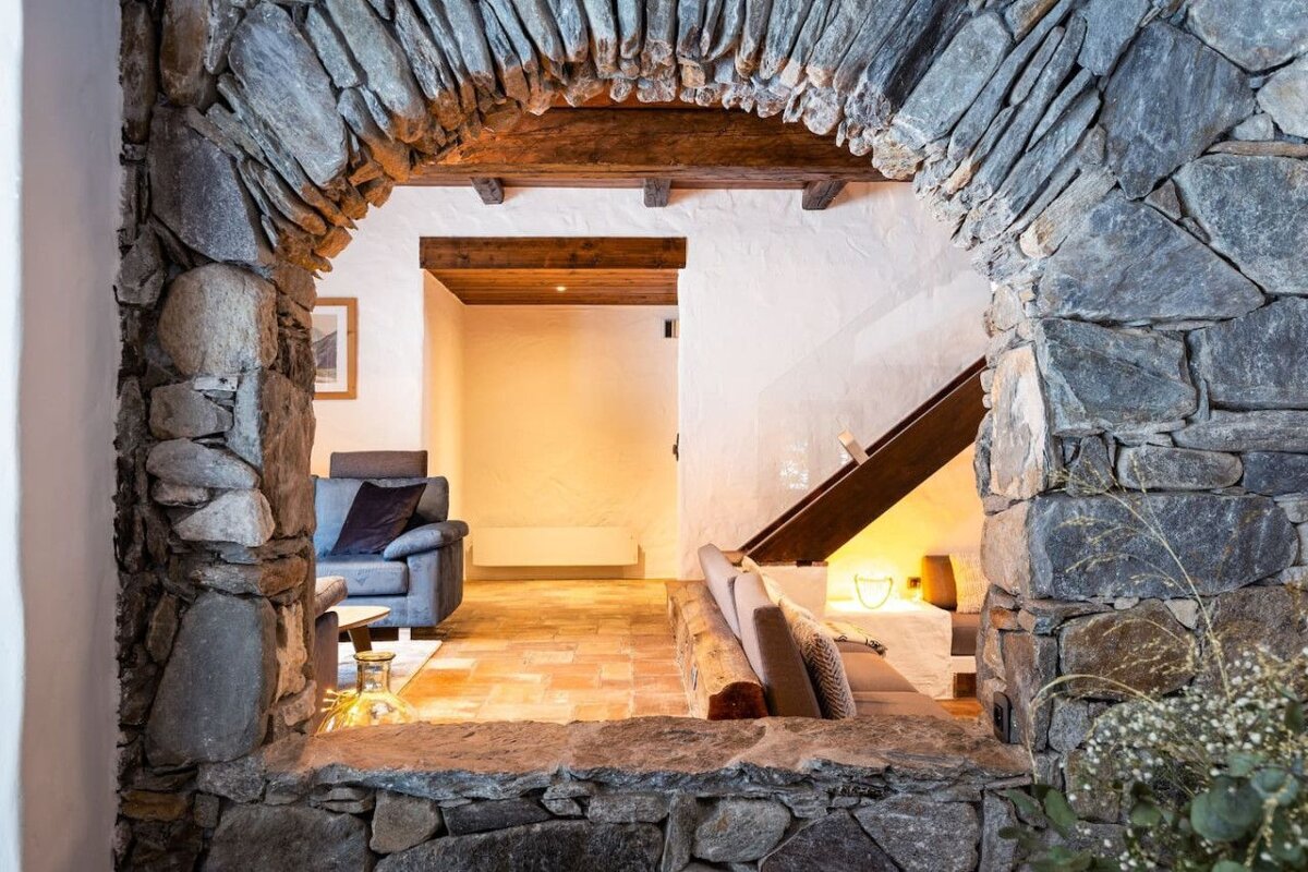 A view of a living room through a stone archway