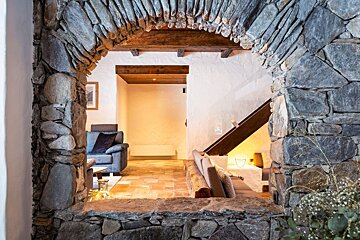 A view of a living room through a stone archway