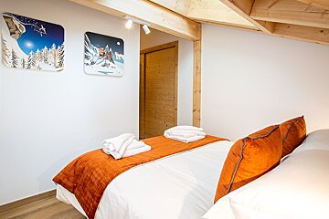 A bedroom with a bed and two paintings on the wall