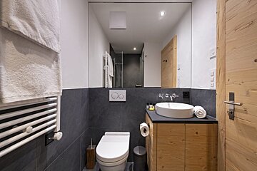 A bathroom with a toilet a sink and a mirror