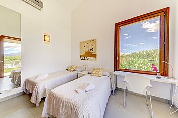 A bedroom with two twin beds and a large window