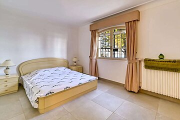 A bedroom with a large bed and two lamps