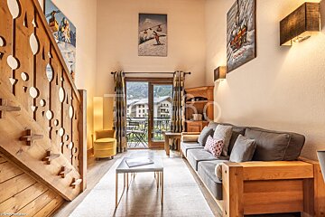 A living room with a wooden staircase and a couch