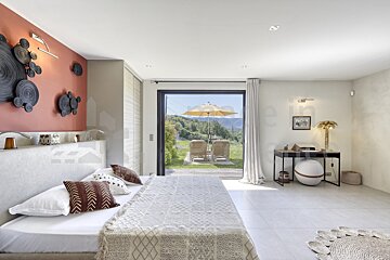 A bedroom with a large bed and a sliding glass door
