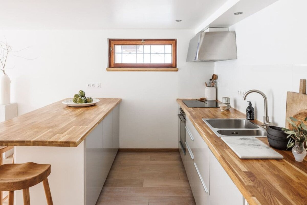A kitchen with wooden counter tops and white cabinets