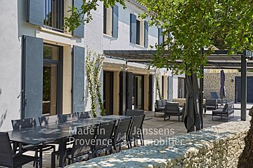 A table and chairs in front of a building that says made in provence