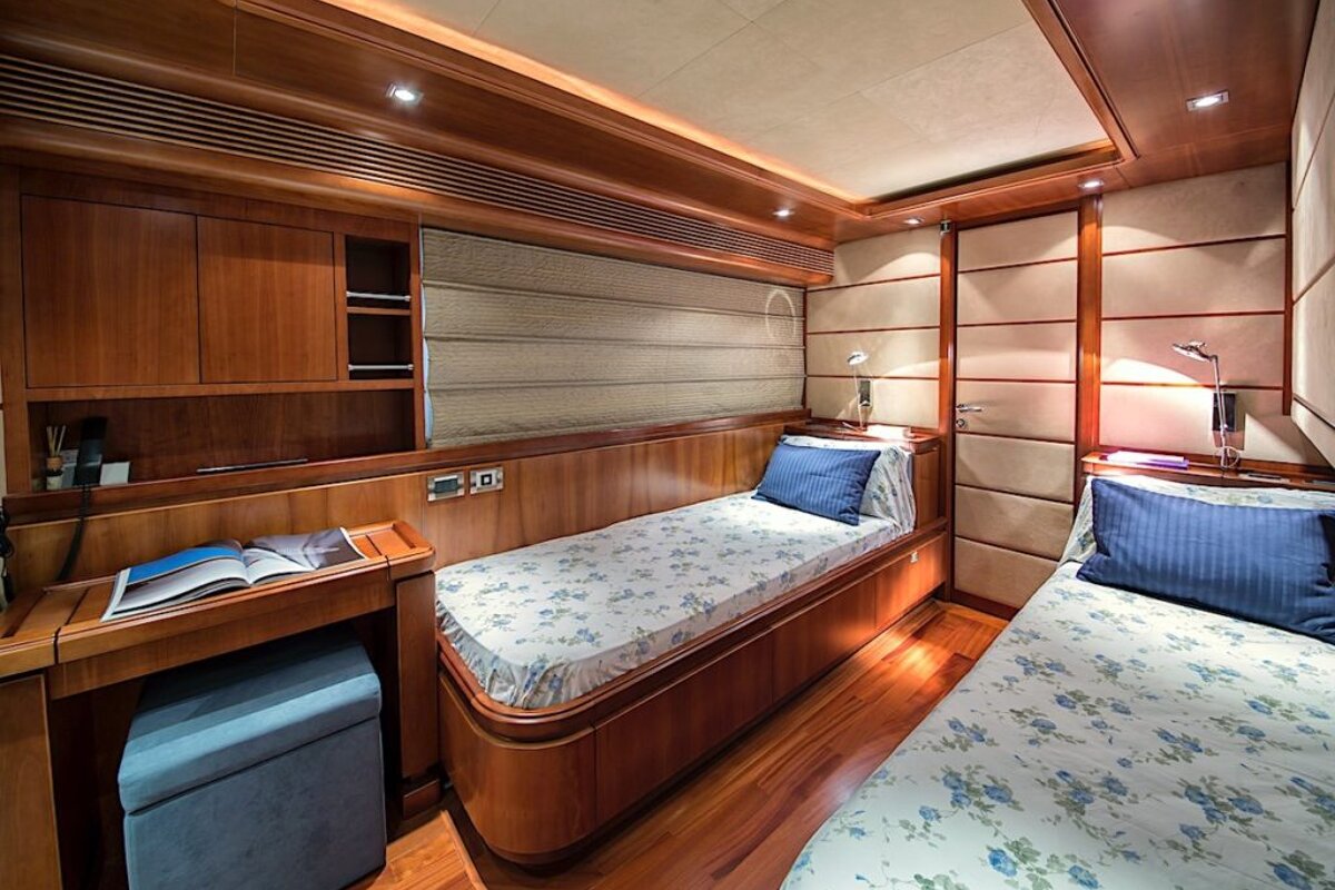 A bedroom with two beds and a desk with a book on it