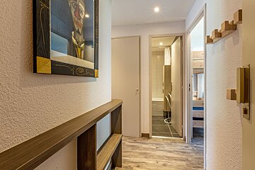 A living room with a purple couch and a wooden table