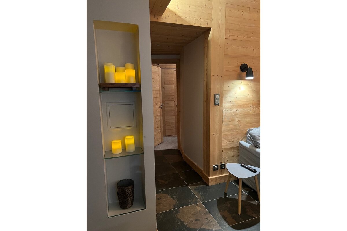 A shelf with candles on it is next to a couch