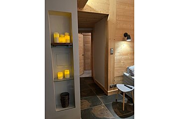 A shelf with candles on it is next to a couch