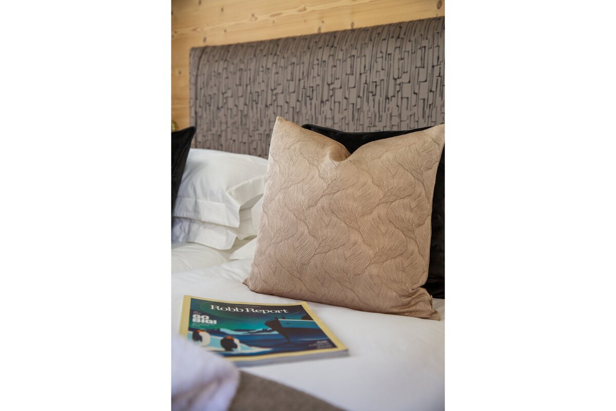 A bed with a pillow and a book that says bob 's report on it