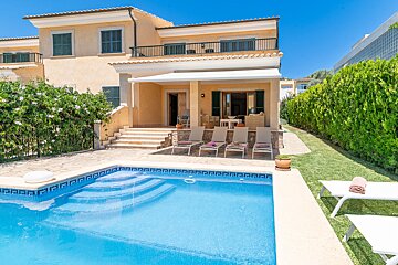 A large house with a swimming pool in front of it