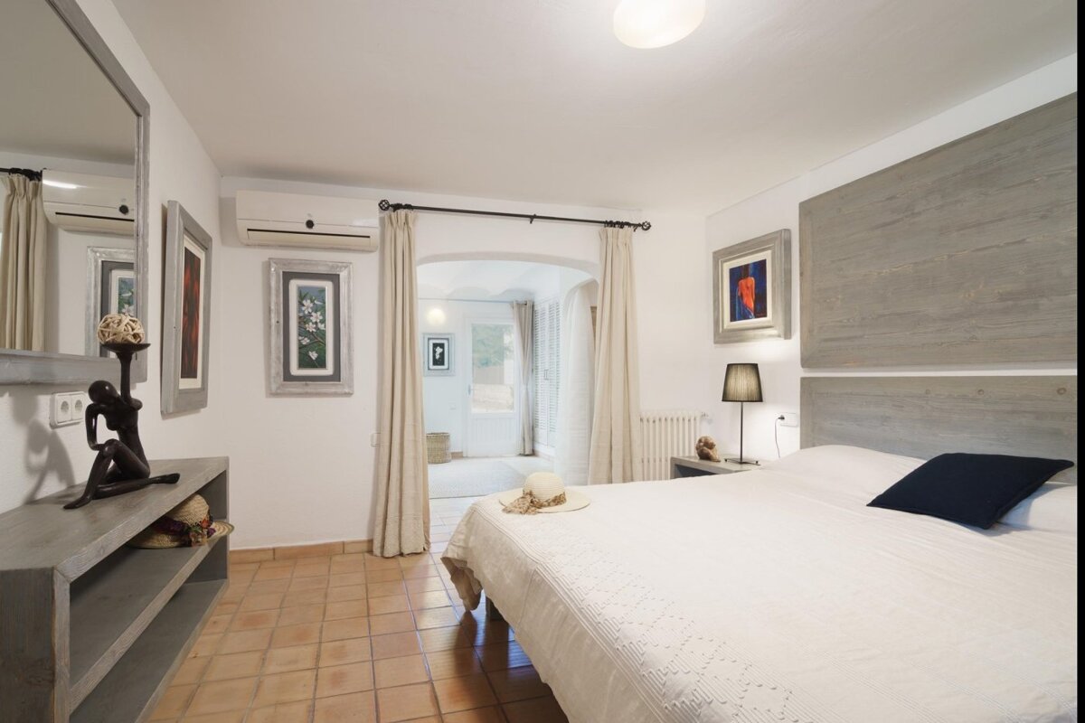 A bedroom with a large bed and a mirror