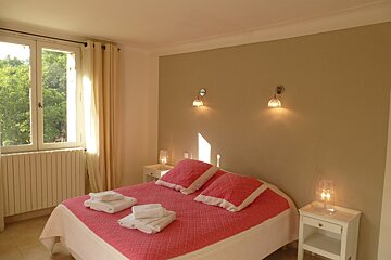 A bedroom with a pink bed and two nightstands