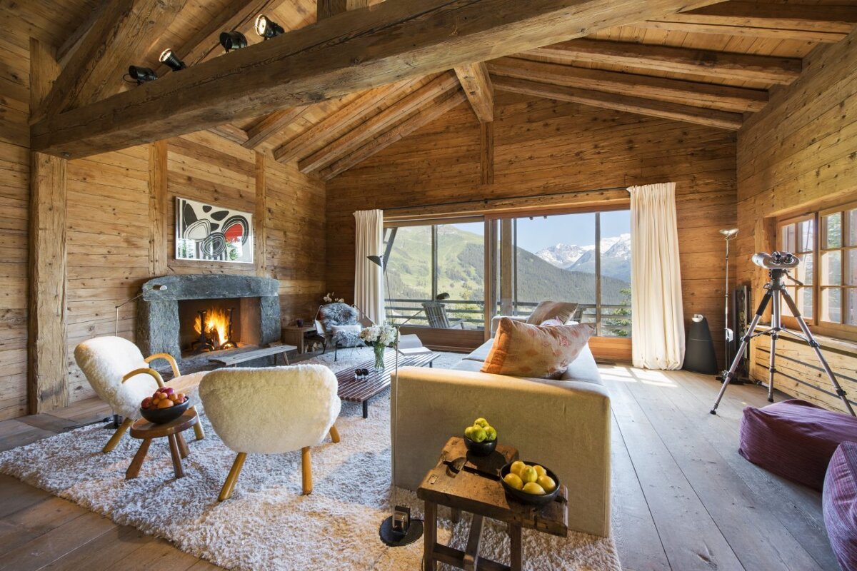 A living room with a fireplace and mountains in the background