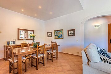 A dining room with a table and chairs and a couch
