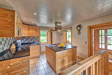A kitchen with wooden cabinets and a clock on the wall