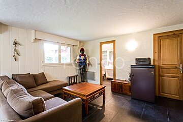 A living room with a couch and a small fridge