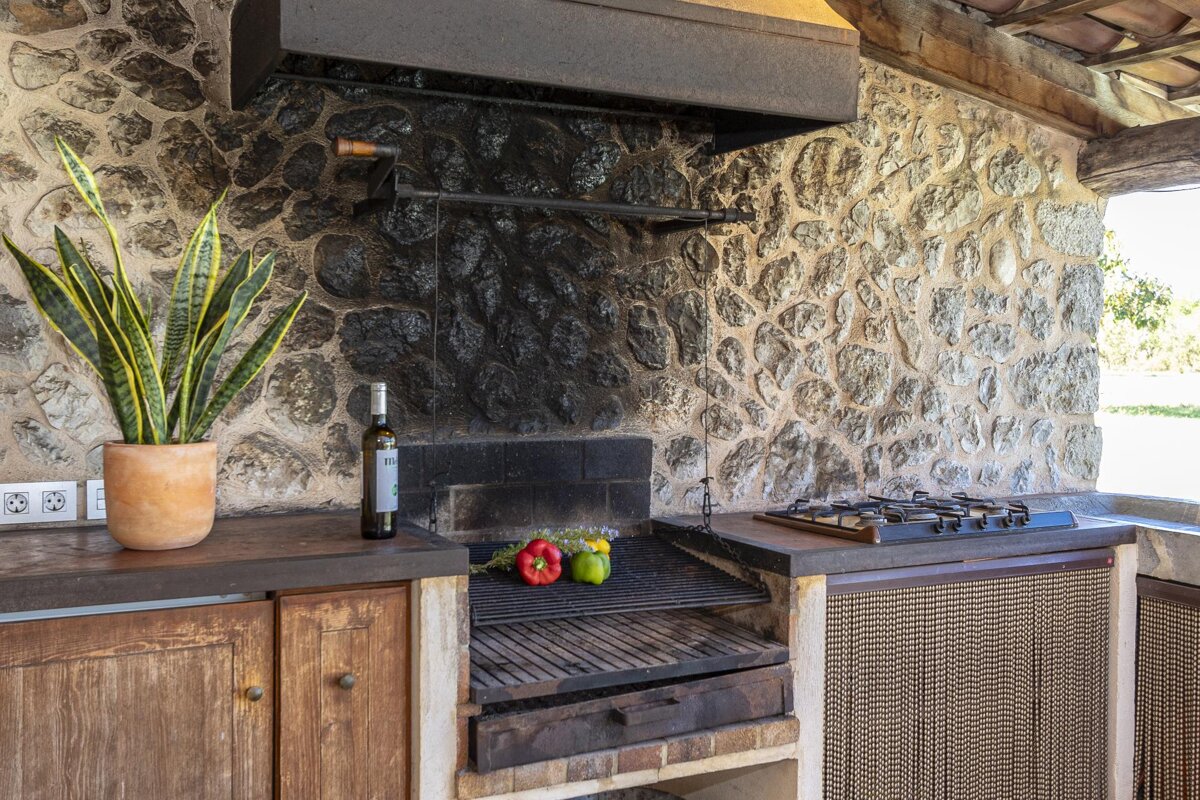 A bottle of wine sits on a counter next to a grill