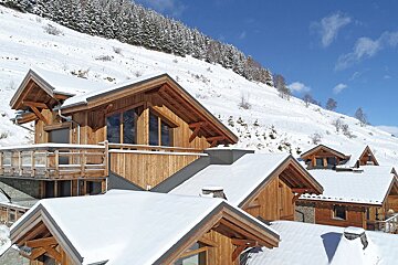 A snow covered roof of a wooden house