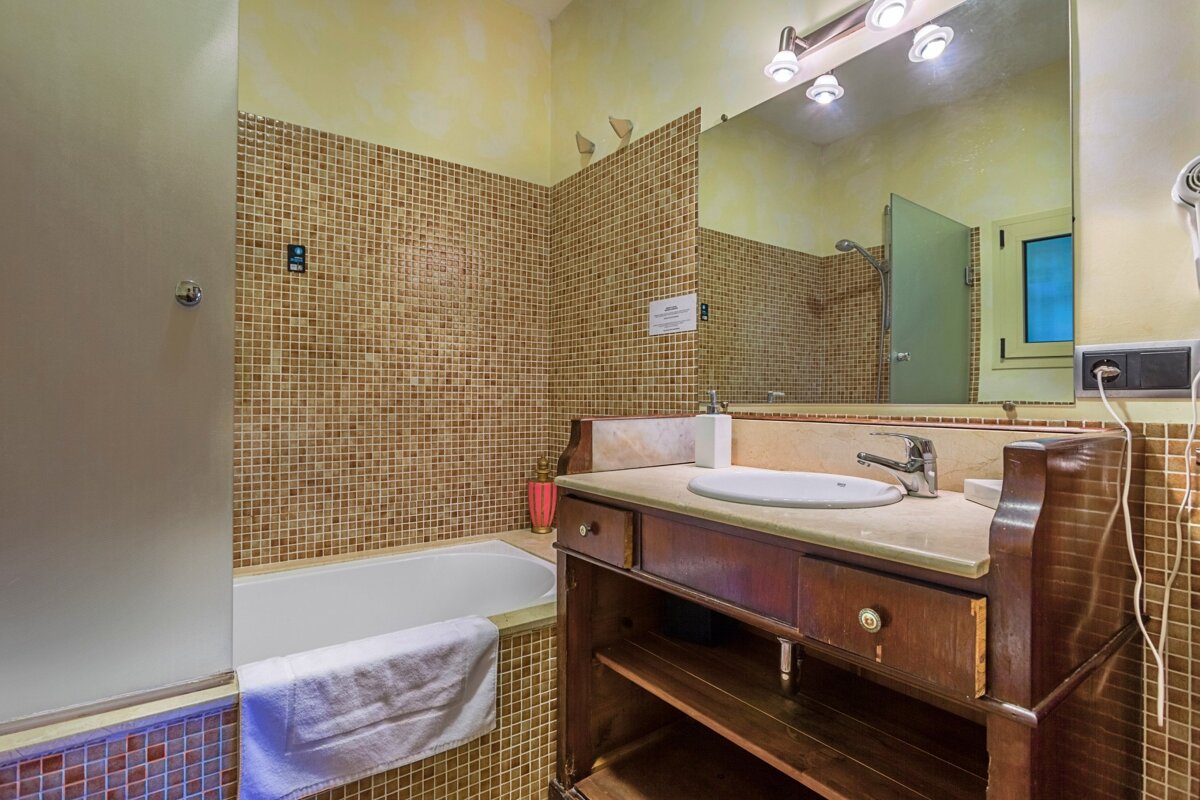 A bathroom with a sink and a bathtub with a sign on the wall that says ' a ' on it