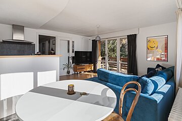 A living room with a blue couch and a white table