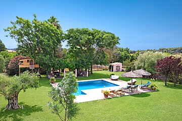 A large swimming pool surrounded by lawn chairs and umbrellas