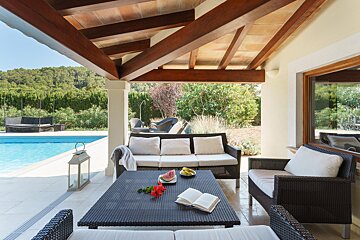 A patio with a couch and a table with a book on it