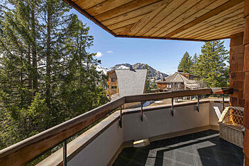 A balcony with a view of mountains and trees