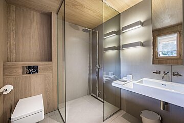A bathroom with a walk in shower and a sink