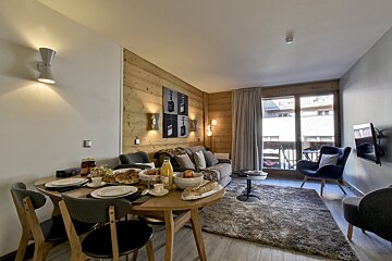 A living room with a table and chairs and a couch