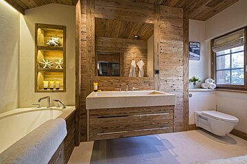 A bathroom with wooden walls and a bathtub