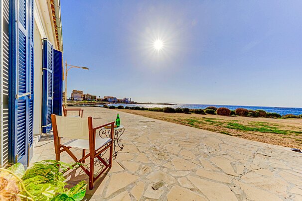 A chair sits on a patio overlooking the ocean