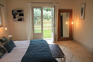 A bedroom with a bed and a large mirror