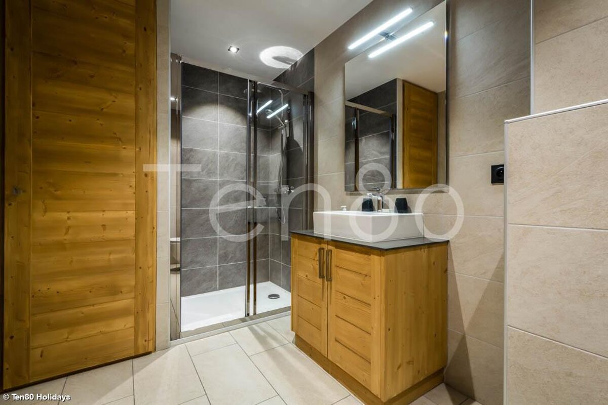 A bathroom with a sink and a shower with the word tenda on the wall