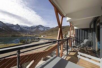 A balcony with a view of mountains and a lake