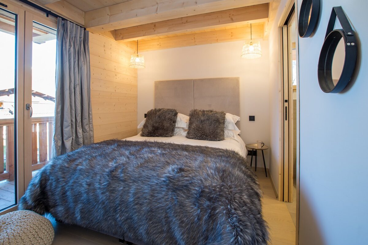 A bedroom with a bed with a fur blanket and pillows