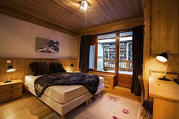 A bedroom with two beds and a nightstand