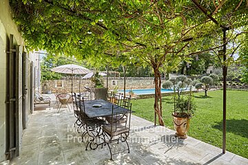 A patio with a table and chairs and a sign that says provence immobilier