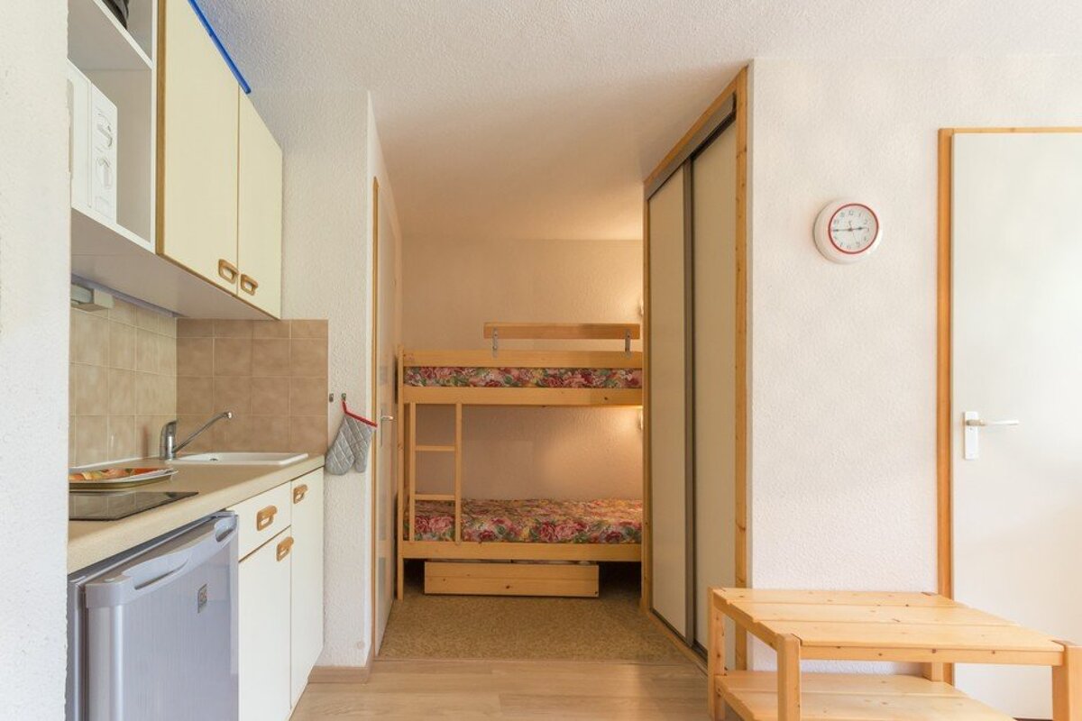 A kitchen with a bunk bed and a clock on the wall