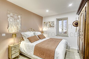 A bedroom with a bed a nightstand and a painting on the wall that says provence