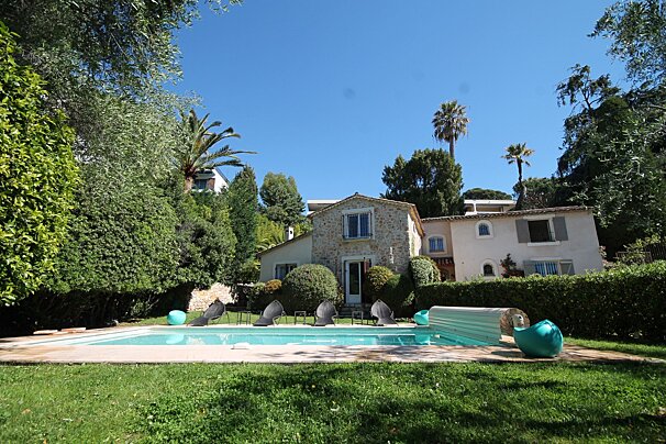 A large house with a swimming pool in front of it