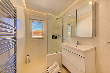 A bathroom with a sink a mirror and a window