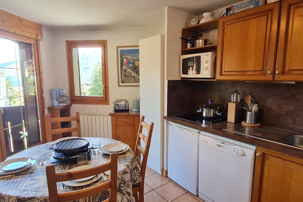 A kitchen with a table and chairs and a microwave