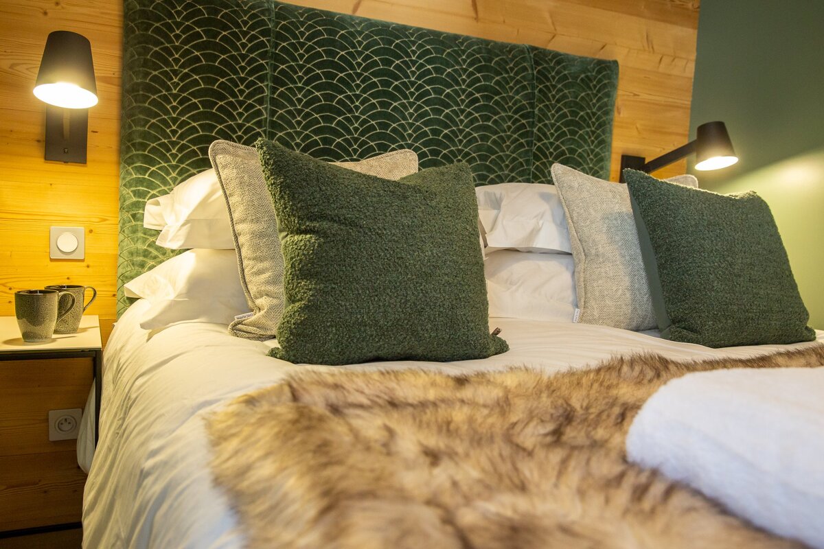 A bed with green pillows and a green headboard