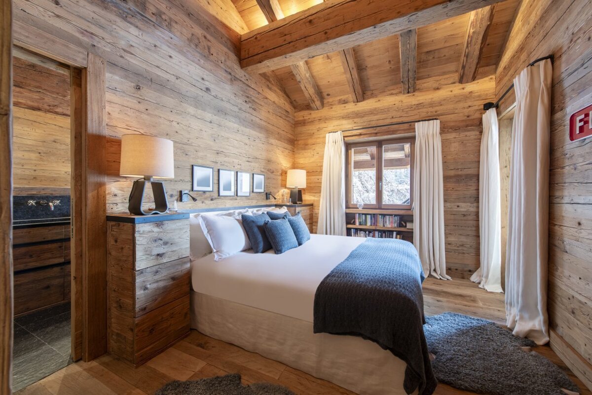 A bedroom with a bed and a fire extinguisher on the wall