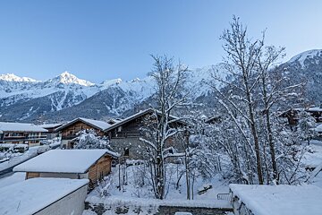 A snowy landscape with mountains in the background
