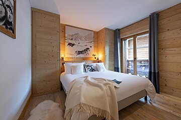 A bedroom with a painting of horses on the wall above the bed